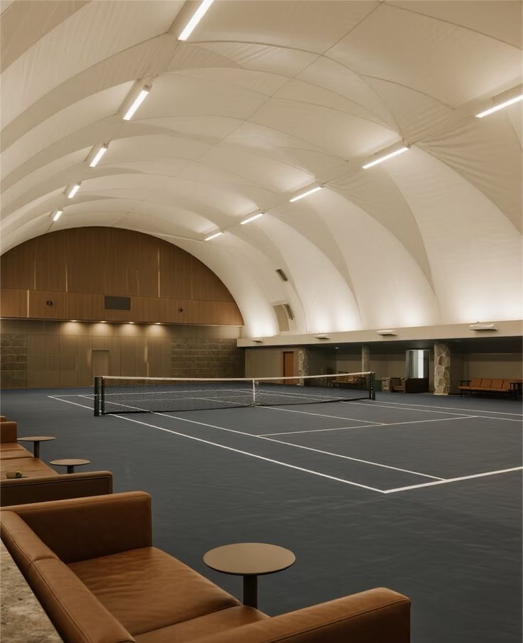 Indoor tennis court with warm wooden seating